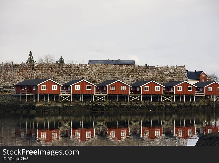 Red houses on stilts at the sea, with stick fish