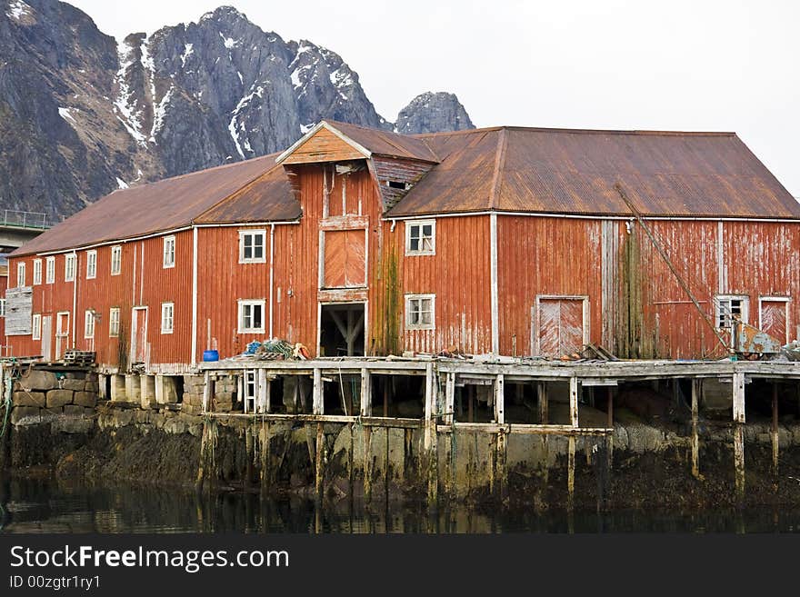 Red house on stilts at the sea