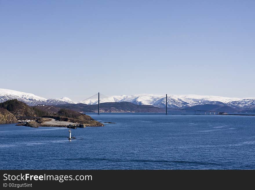 Snow-covered mountains with bridge in the fjord. Snow-covered mountains with bridge in the fjord