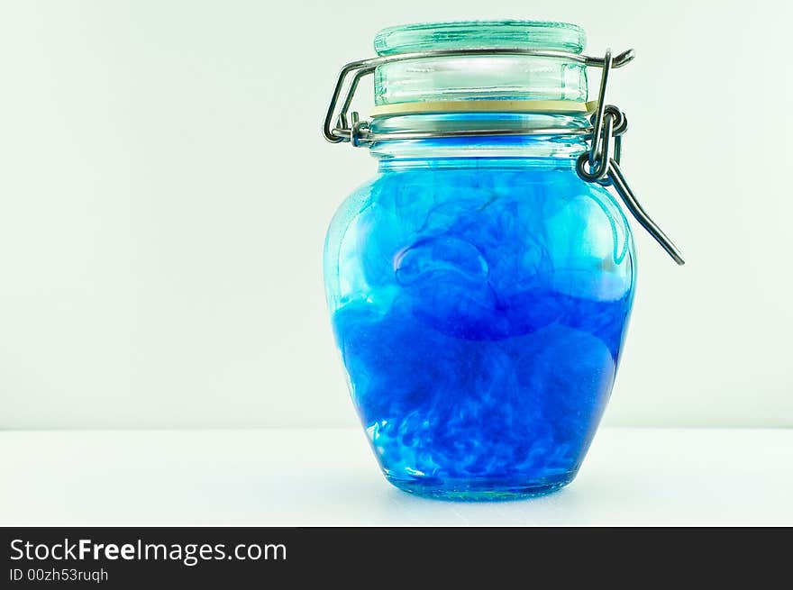 An antique jar full of water and blue colour with the lid closed. An antique jar full of water and blue colour with the lid closed.