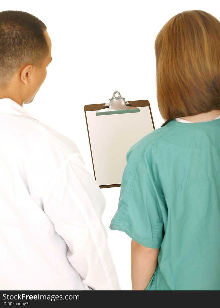 Two medical staff looking at clip board. camera angle from the back. isolated on white. Two medical staff looking at clip board. camera angle from the back. isolated on white