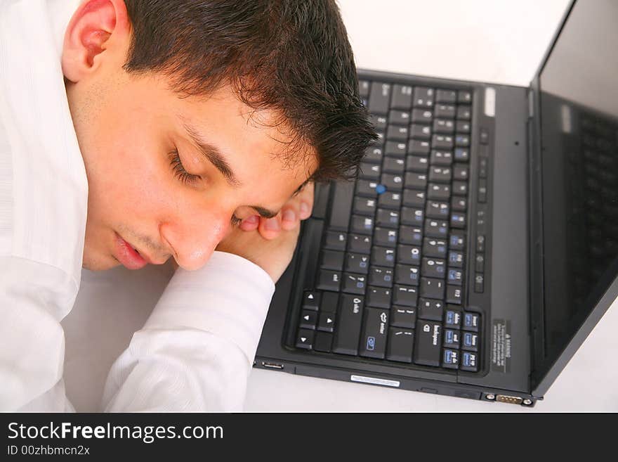 Young man sleeping on a laptop. concept for overworked. Young man sleeping on a laptop. concept for overworked