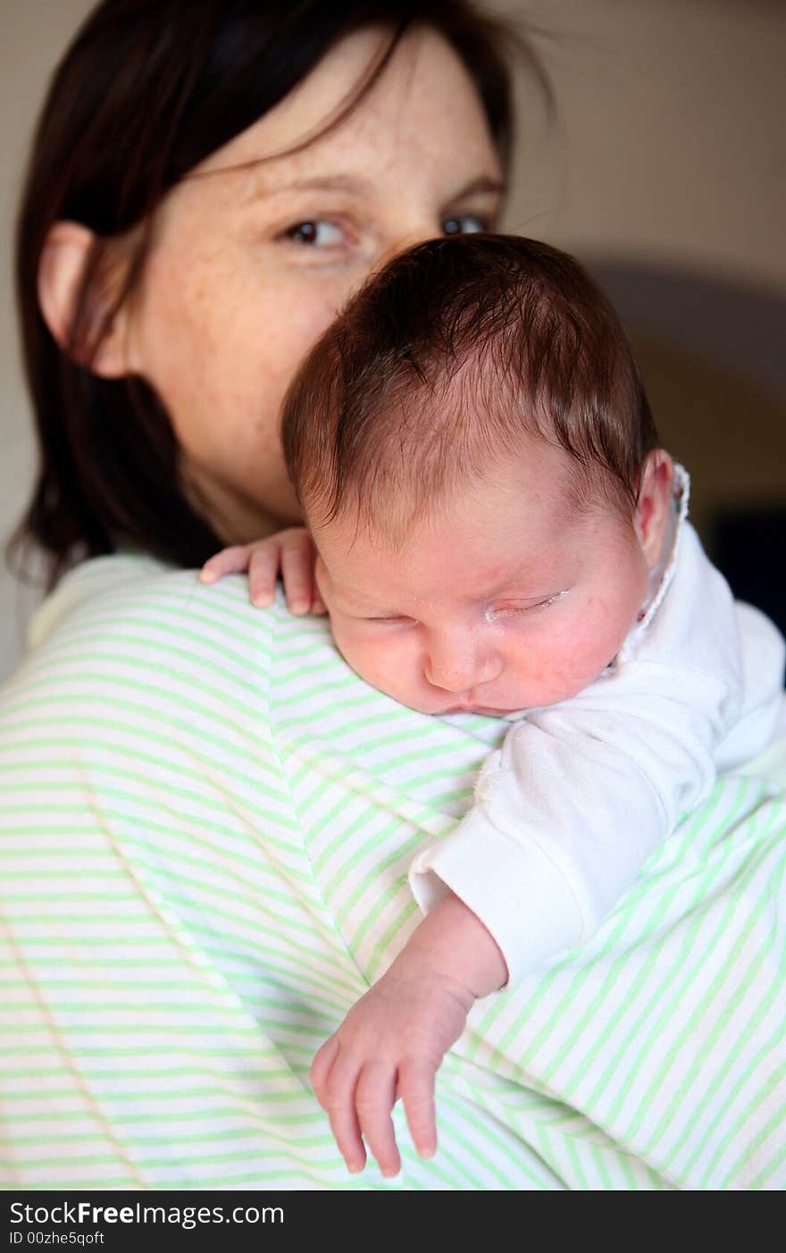 A new born baby  lying over her mother's shoulder. A new born baby  lying over her mother's shoulder