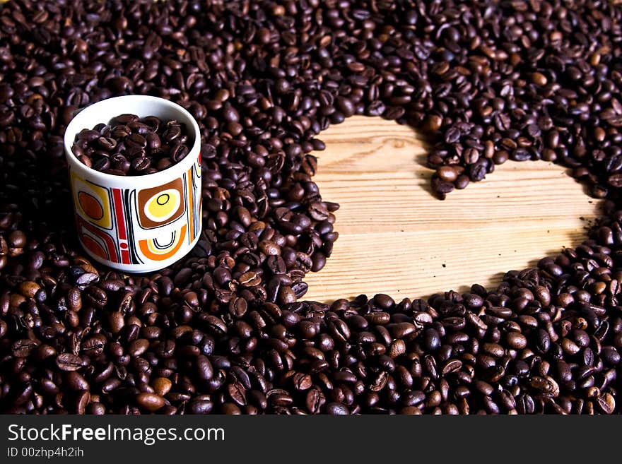 A cup of coffee on coffee beans with heart