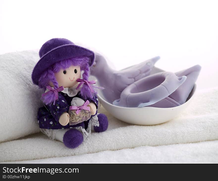 Little doll and summer shapes soaps laying at white towel. Little doll and summer shapes soaps laying at white towel