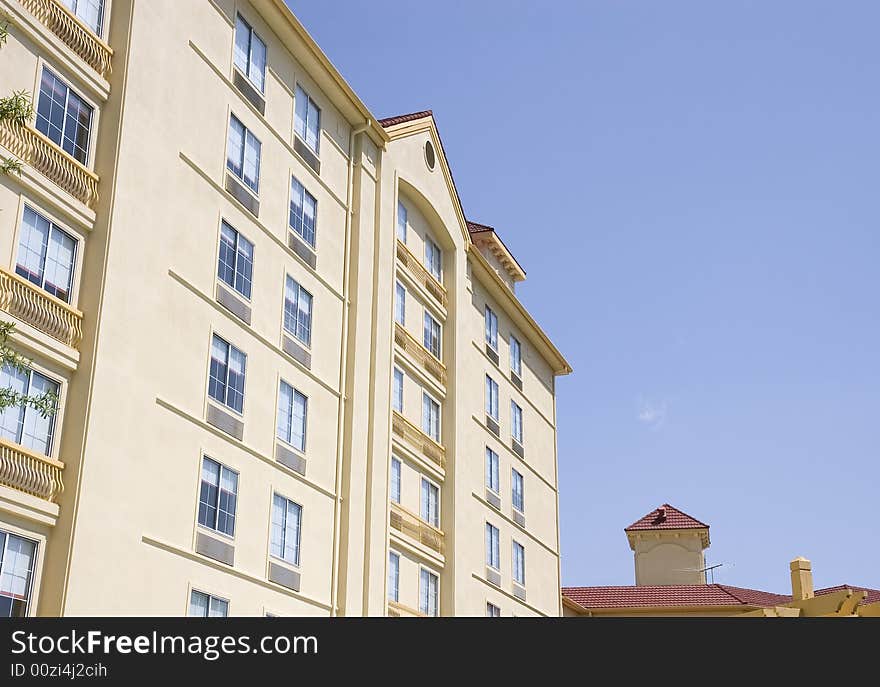 A yellow and gold stucco hotel against a blue sky