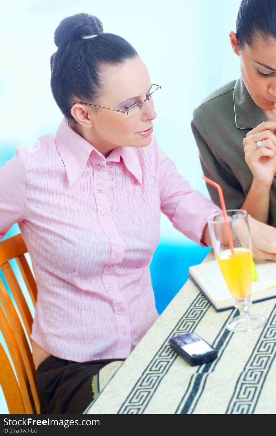 Two young businesswomen working on coffee break, outdoors