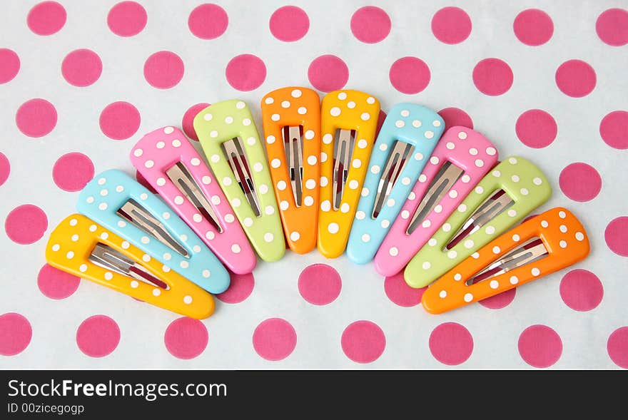 Brightly colored polka dot hair accessories on a polka dot background