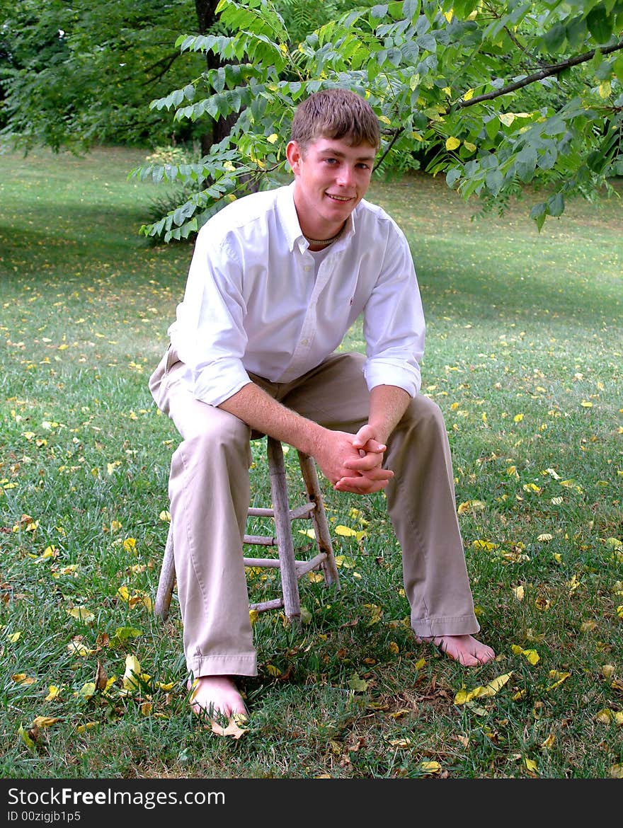 Young man in white shirt and tan pants in outdoor location. Young man in white shirt and tan pants in outdoor location