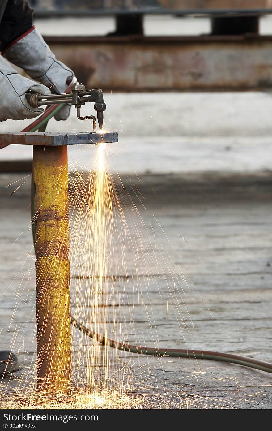 A welder working a torch at shipyard. A welder working a torch at shipyard