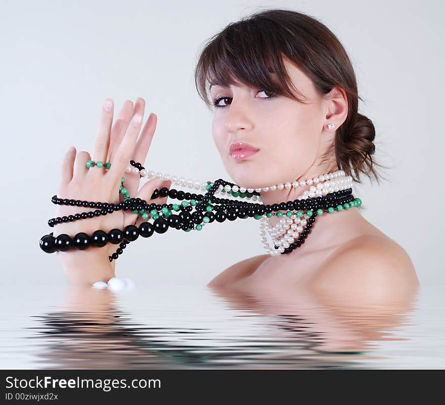 Young beautiful girl with a great number beads on a neck, which winds them on a hand. Young beautiful girl with a great number beads on a neck, which winds them on a hand