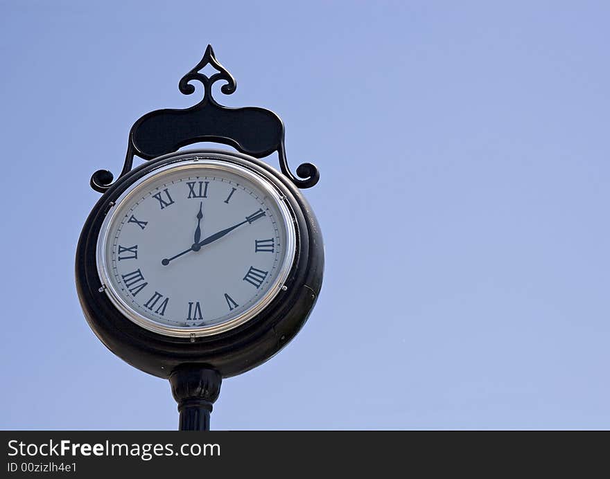 A traditional city clock against a blue sky. A traditional city clock against a blue sky