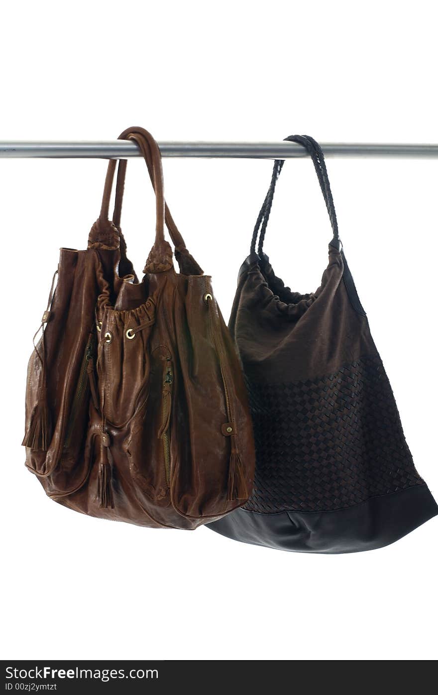 Two Fashionable handbags hanging on white background