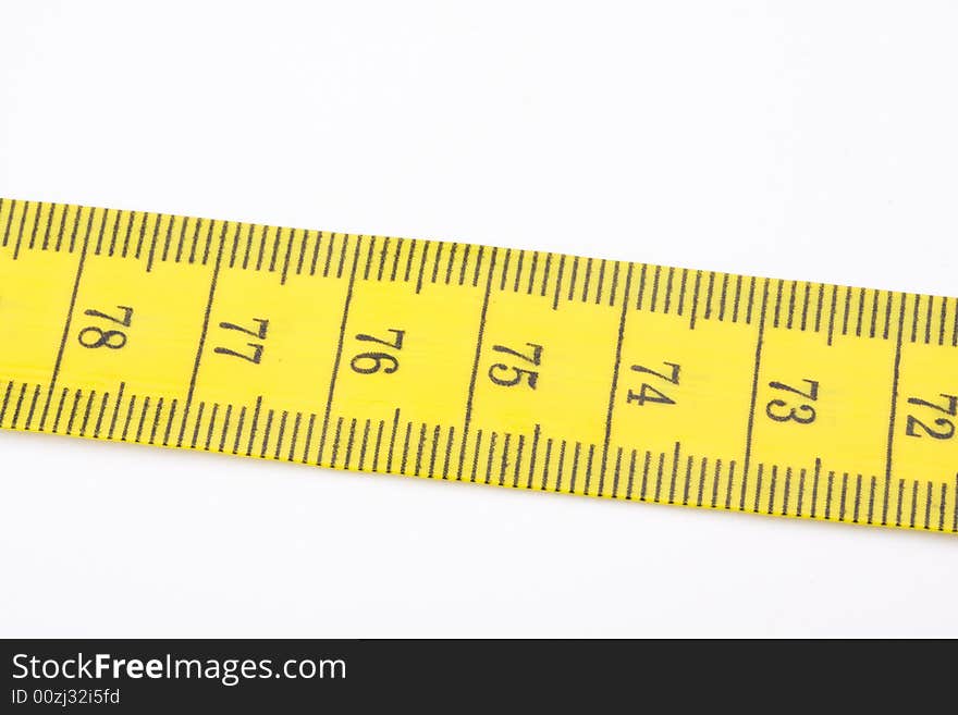 Yellow measuring tape used by tailors on white