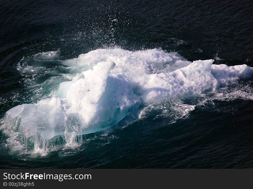 A moving iceberg collides with water in alaska