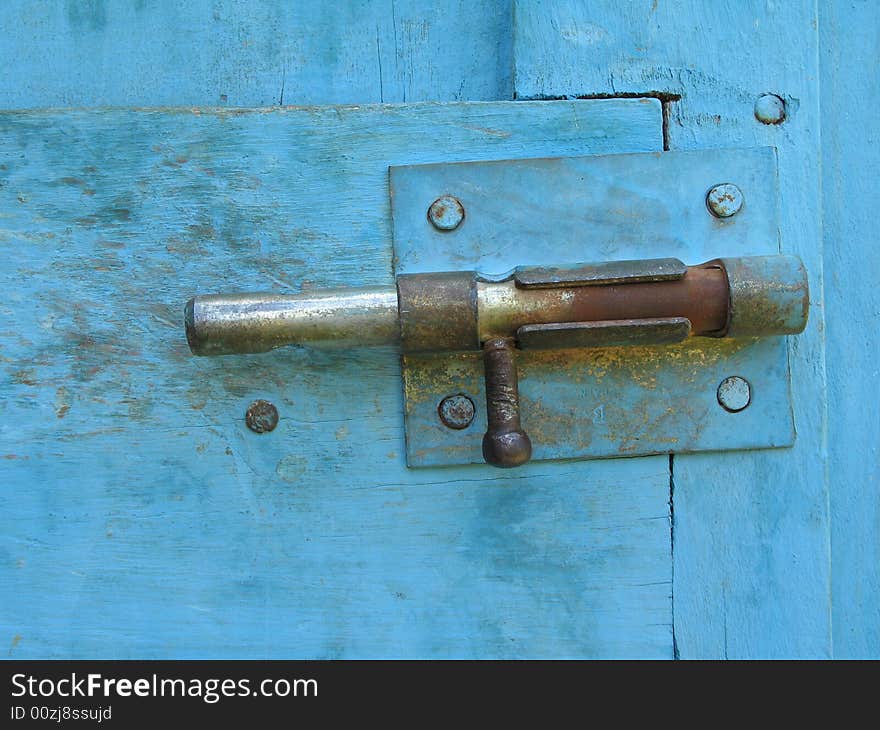 An old lock on a blue door