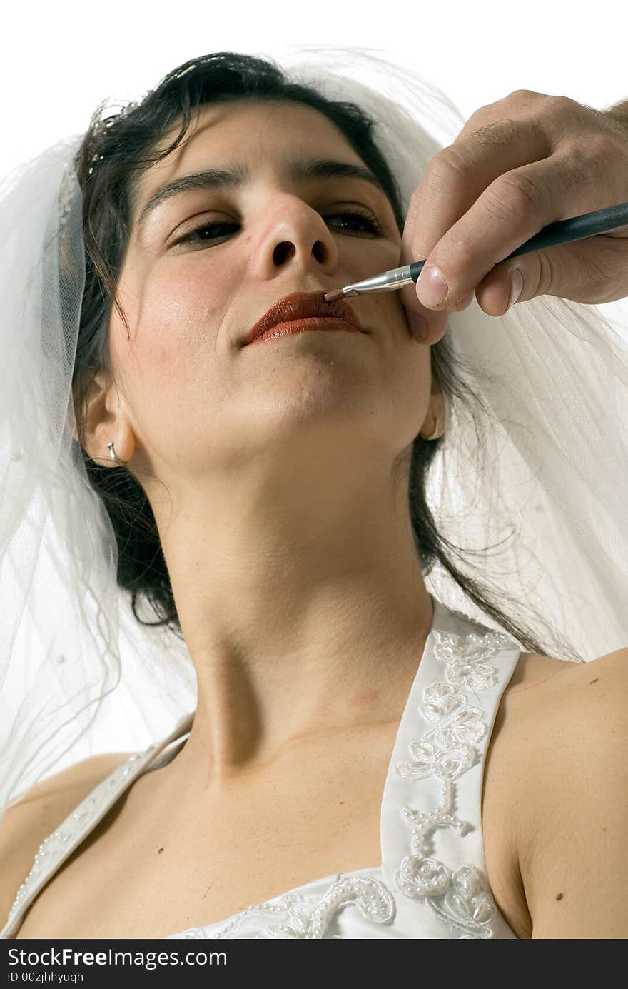 A soon-to-be wife tilts her chin up while getting her lips covered with a red shade of lip liner. - vertically framed. A soon-to-be wife tilts her chin up while getting her lips covered with a red shade of lip liner. - vertically framed