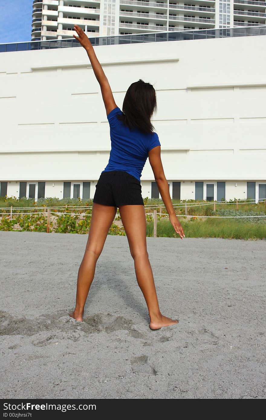 Young woman with back towards the camera performing a yoga stretch. Young woman with back towards the camera performing a yoga stretch.