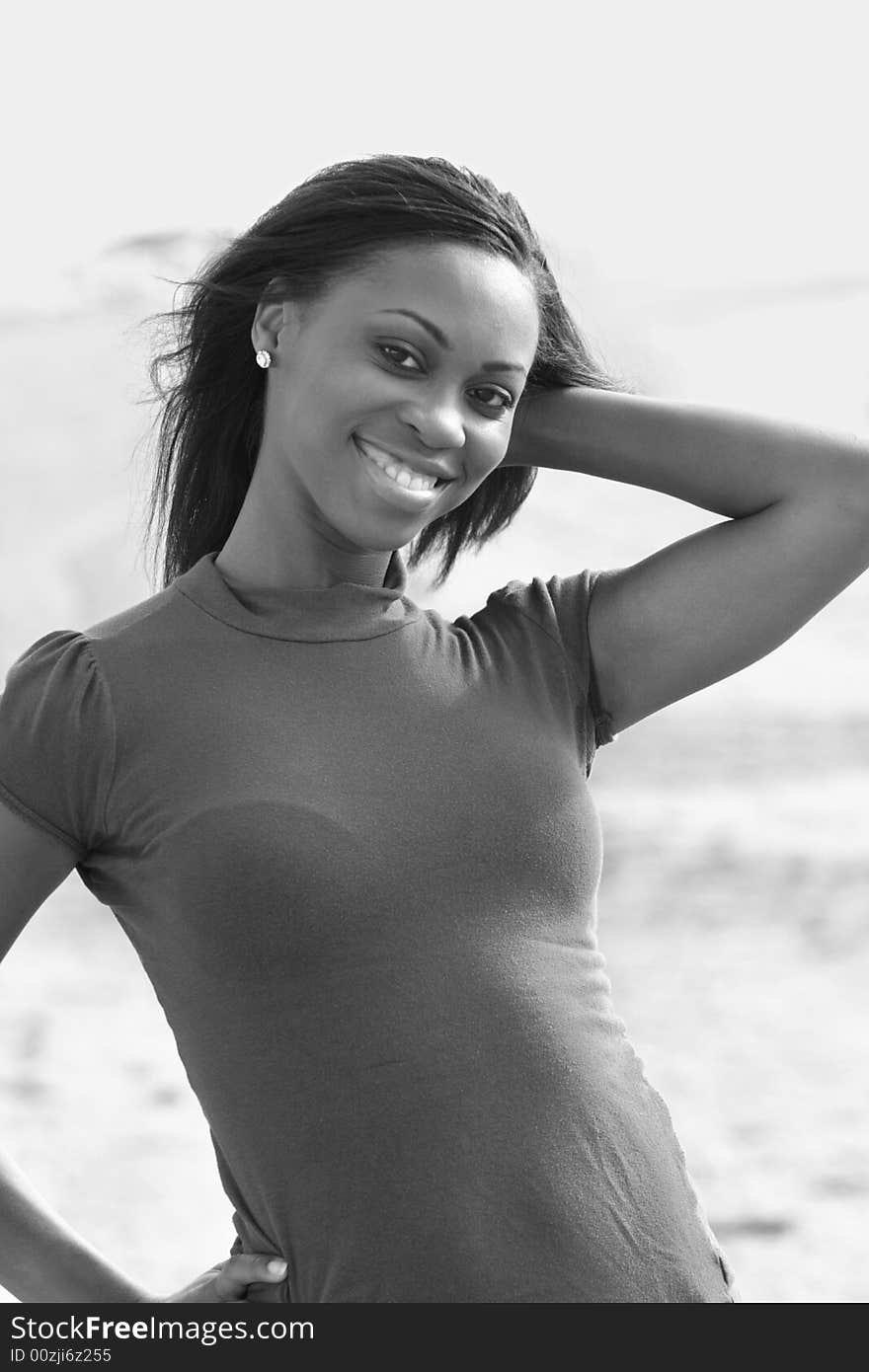 Black and white image of a young female smiling and posing for the camera. Black and white image of a young female smiling and posing for the camera.