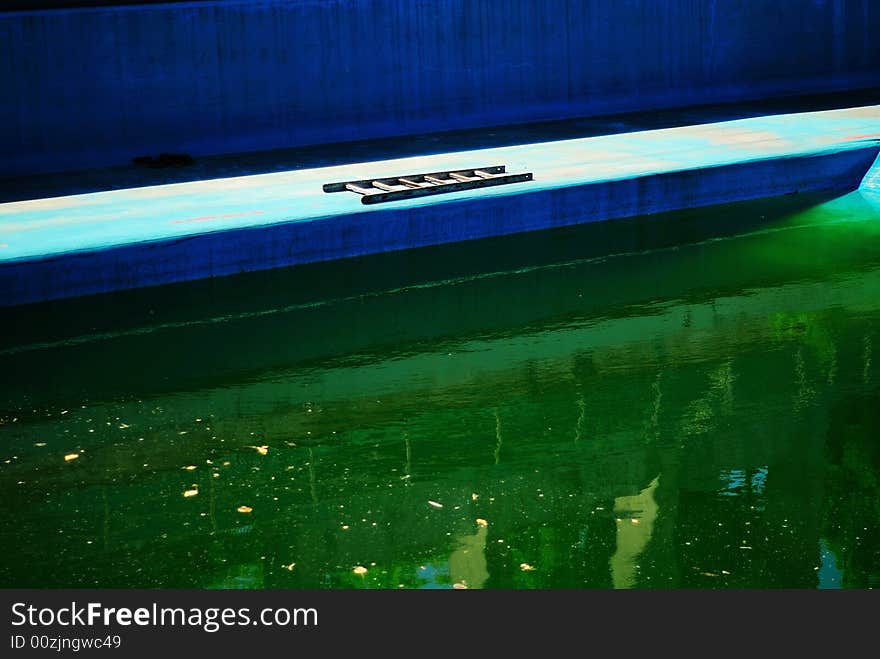 A dirty swimming pool in green color.