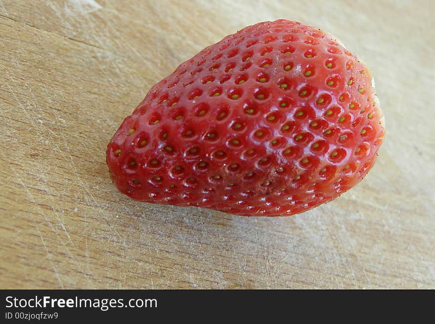 Single strawberry close-up image, isolated on a wooden board

*RAW format available