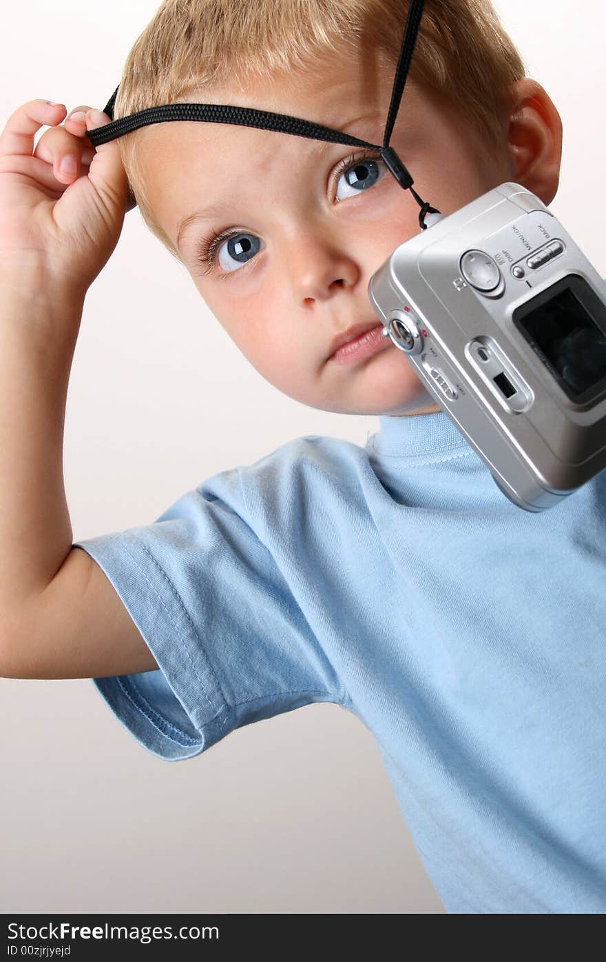 Toddler trying to hang the camera round his neck. Toddler trying to hang the camera round his neck