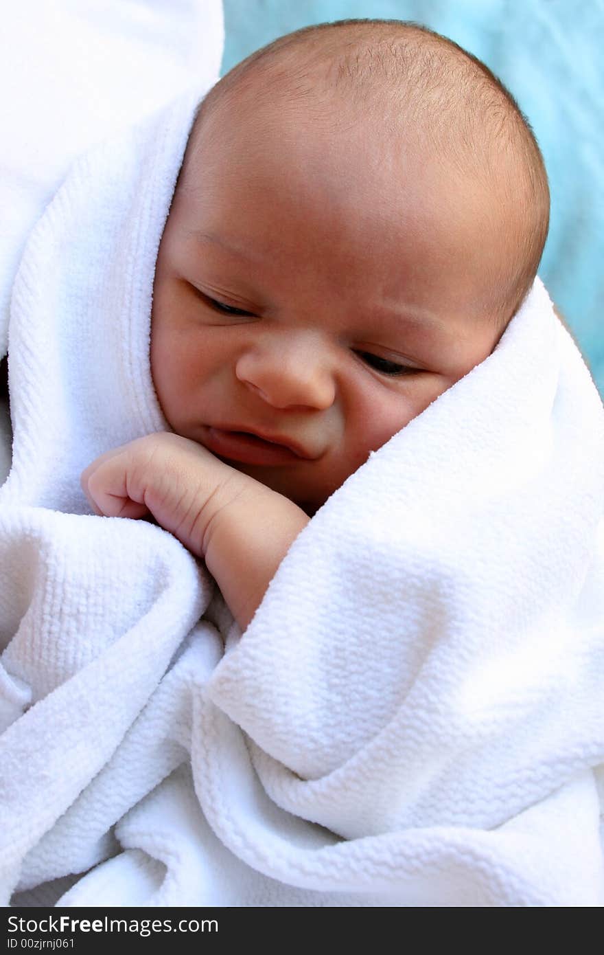 Week old baby boy on a blue blanket early in the morning. Week old baby boy on a blue blanket early in the morning