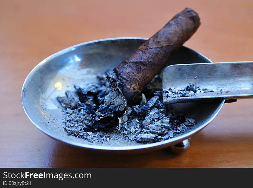 Small Cigar in an old metallic Ashtray, Close shot. Small Cigar in an old metallic Ashtray, Close shot