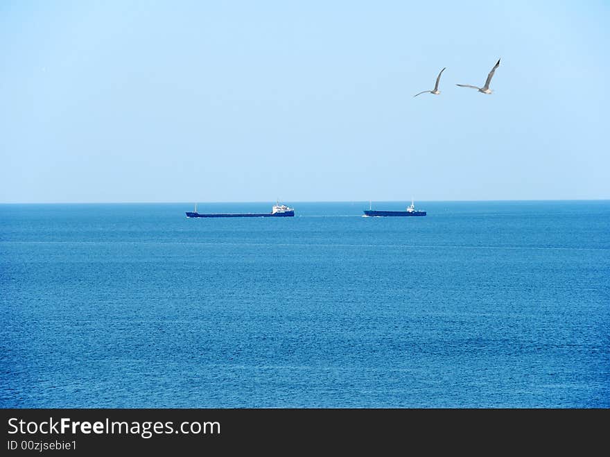 Commersial ships go to sea over blue sky. Commersial ships go to sea over blue sky