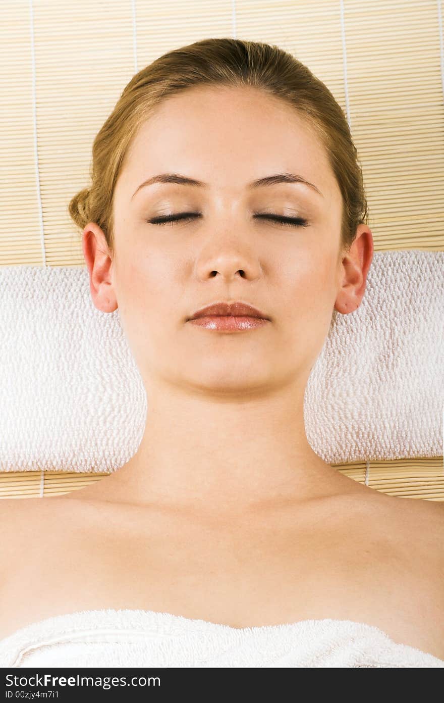 Young beautiful woman in a spa with towels is relaxing. Young beautiful woman in a spa with towels is relaxing