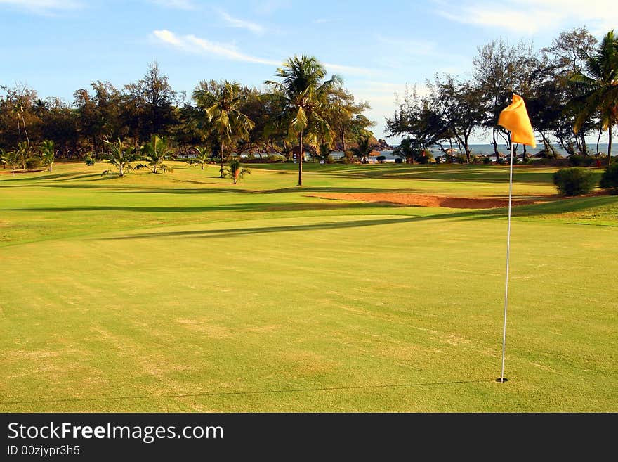 Shot of a beautiful green on a tropical golf course surrounded with palm trees. Shot of a beautiful green on a tropical golf course surrounded with palm trees.