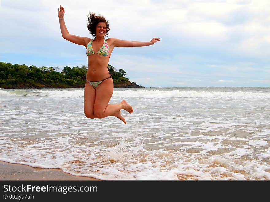 Young beautiful woman at the beach enjoying the sun and jumping for joy. Ideal summer / vacation shot. Young beautiful woman at the beach enjoying the sun and jumping for joy. Ideal summer / vacation shot.