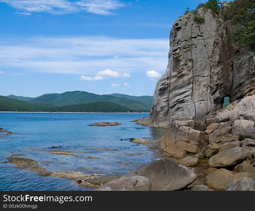 A very small bay among fancy rocks. Seacoast of Petrova island - pearl of nature state reserve Lazovsky. Russian Far East, Primorye. A very small bay among fancy rocks. Seacoast of Petrova island - pearl of nature state reserve Lazovsky. Russian Far East, Primorye.