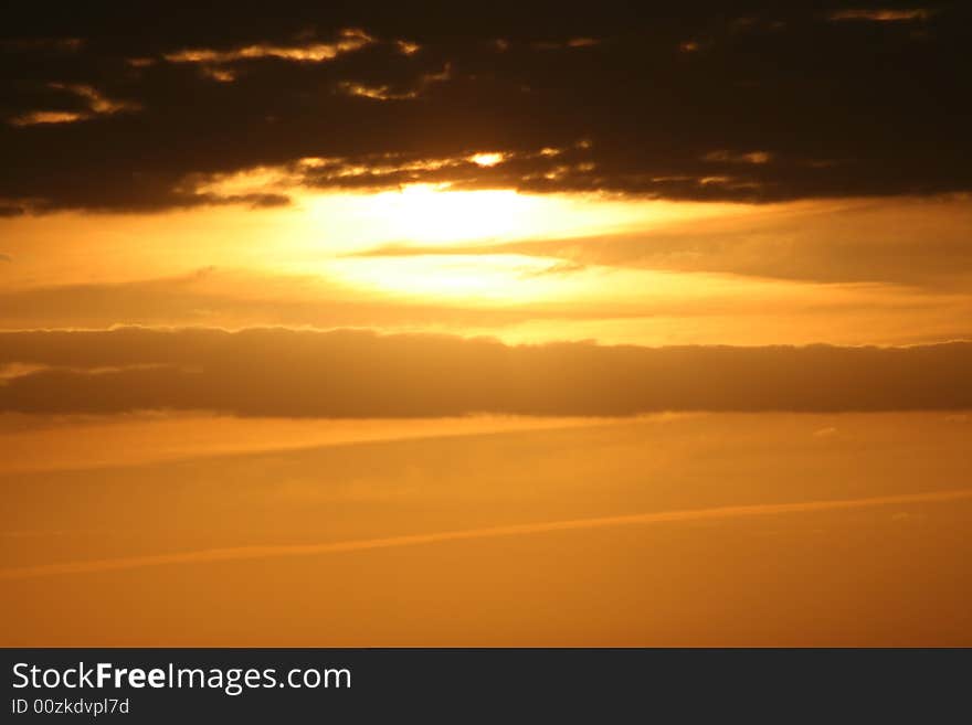 An orange and yellow sunset with clouds. An orange and yellow sunset with clouds