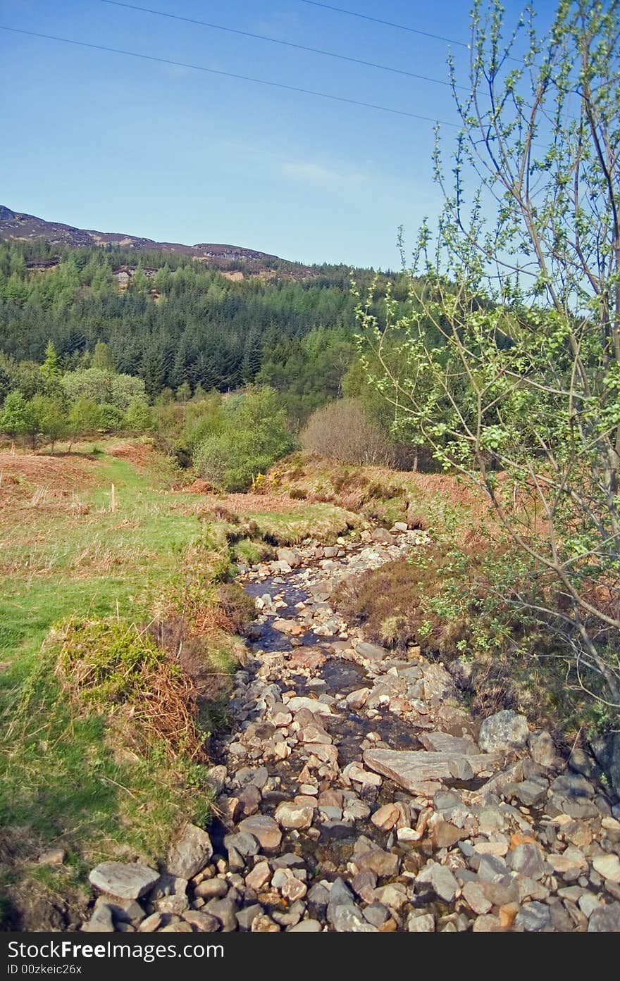 A rocky stream runs through glen ogle in scotland. A rocky stream runs through glen ogle in scotland