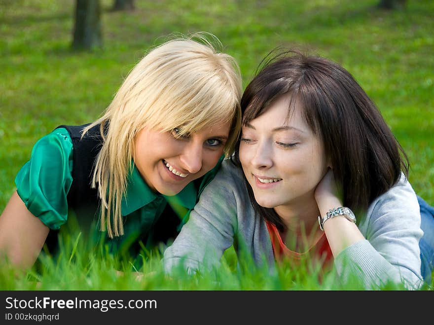 Happy blonde and brunette rest on the nature. Happy blonde and brunette rest on the nature