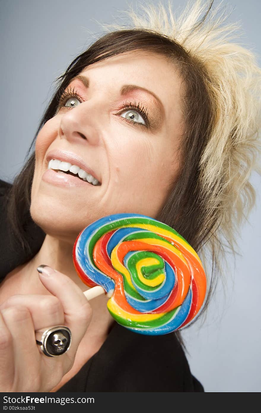 Portrait of a creative businesswoman with wild hair holding a lollipop. Portrait of a creative businesswoman with wild hair holding a lollipop