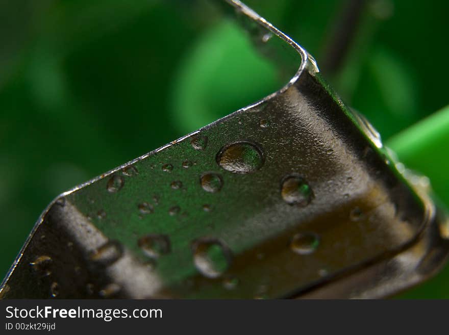 Metal parts covered by drops on the green background