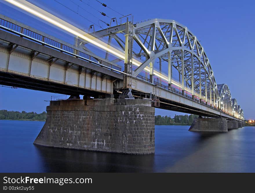 The night express train on the bridge across Daugava river. The night express train on the bridge across Daugava river.