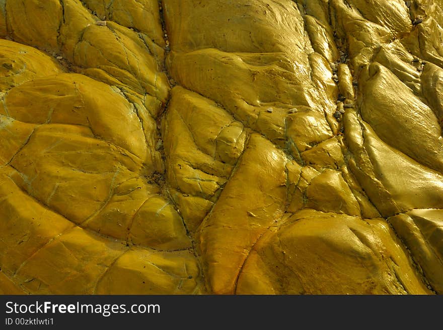 A closeup of wet sandstone rock by the seashore. Lit from the side. Suitable for abstract background. A closeup of wet sandstone rock by the seashore. Lit from the side. Suitable for abstract background.