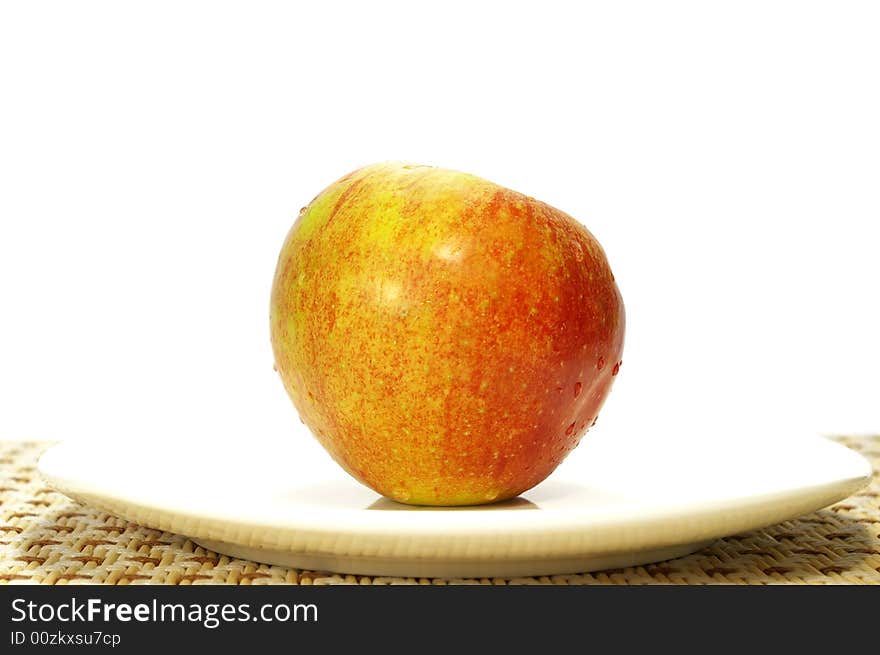 Ripe juicy apple on a white plate. Ripe juicy apple on a white plate