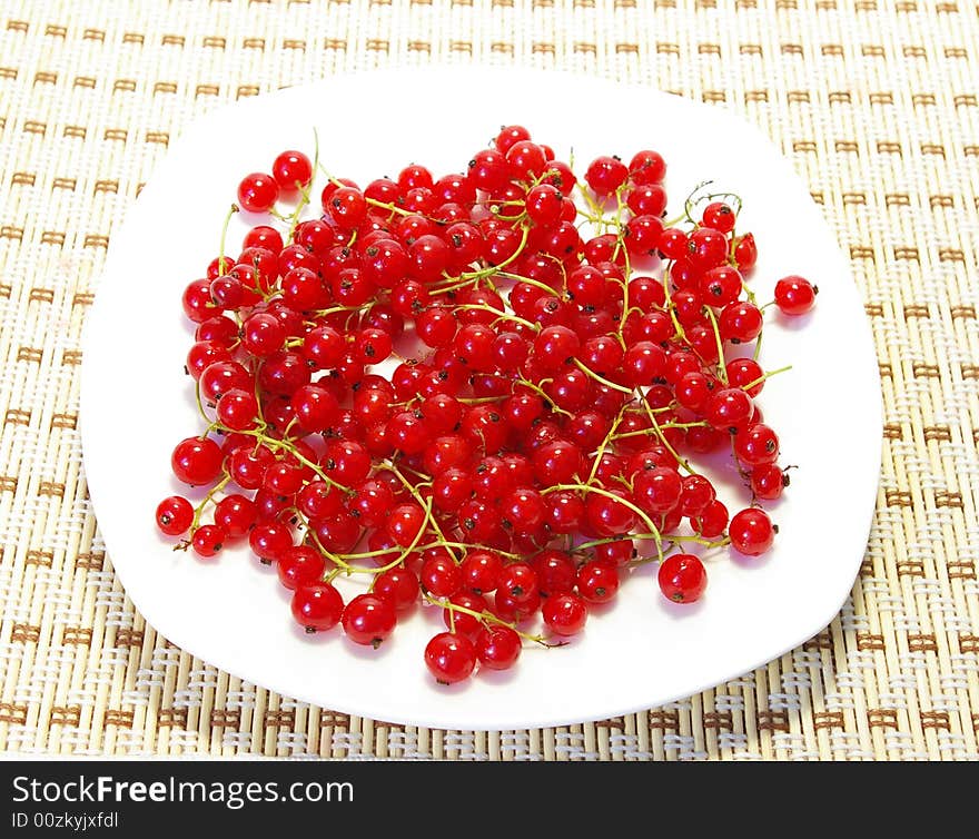 Red and black currant on a white plate. Red and black currant on a white plate