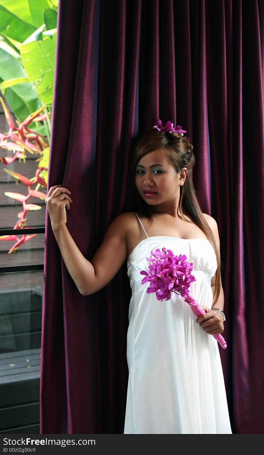 Portrait of a beautiful Asian bride with flowers in her hair.