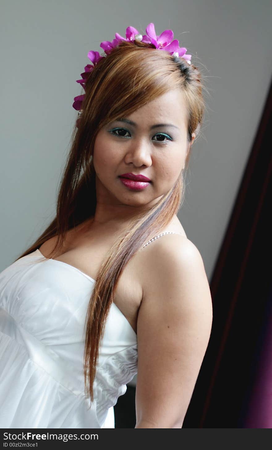 Portrait of a beautiful Asian bride with flowers in her hair.