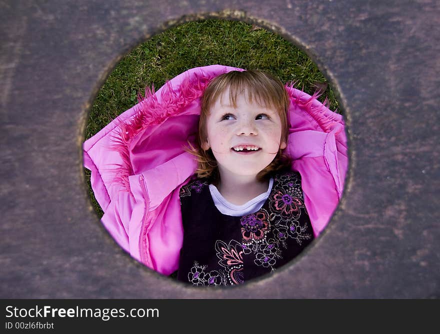 Little girl looking through a hole. Little girl looking through a hole