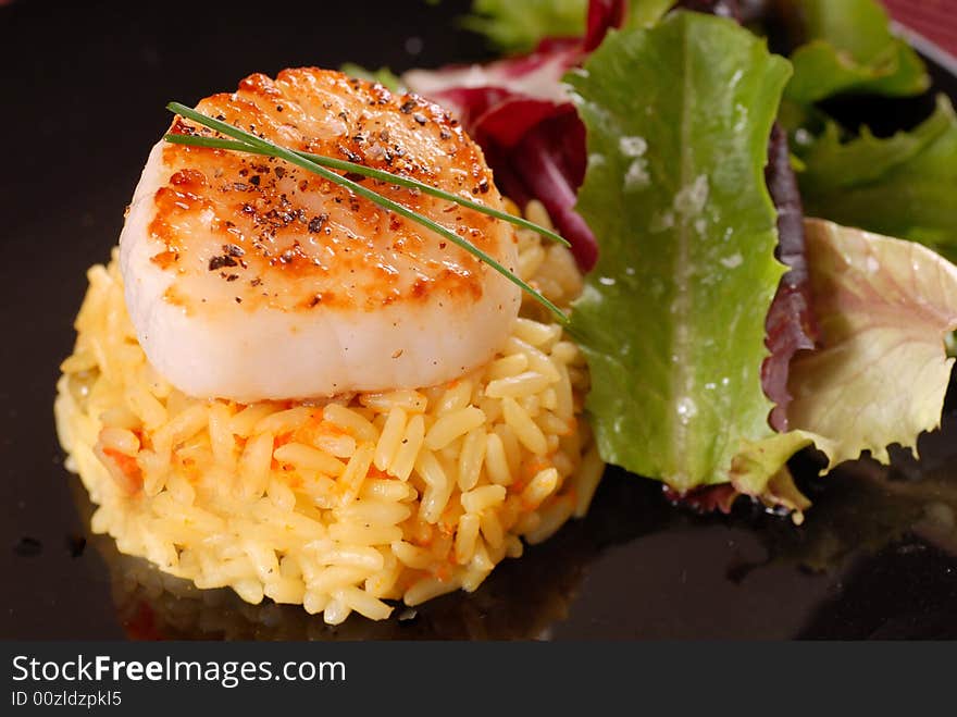 Scallop on bed of saffron rice with salad