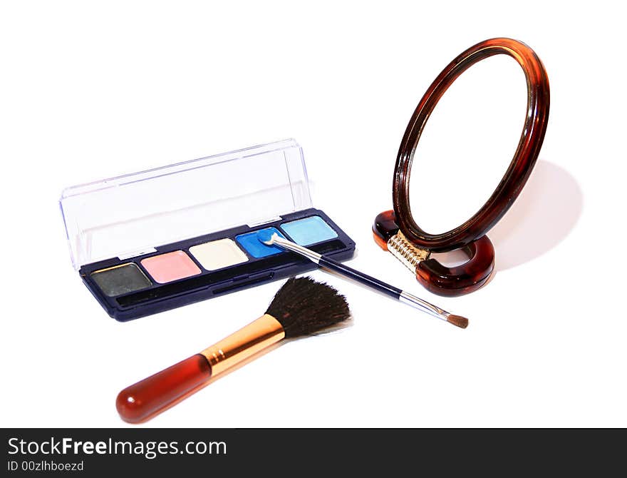 Cosmetic set - shadows for eyes, a mirror and a brush