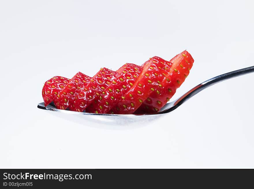 Closeup of juicy red sliced strawberry on a spoon. Closeup of juicy red sliced strawberry on a spoon