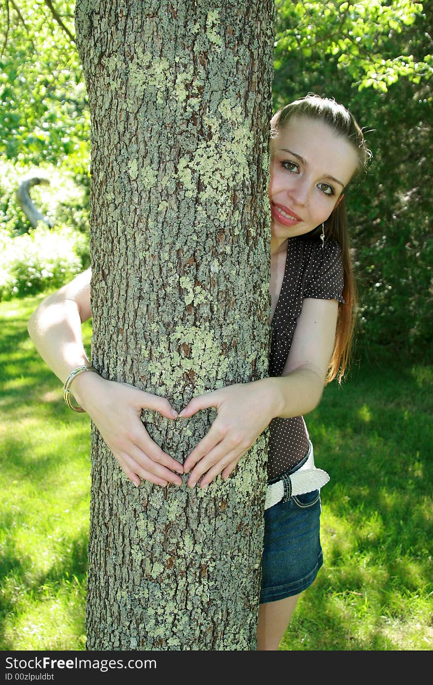 A young girl hugging a tree. A young girl hugging a tree.