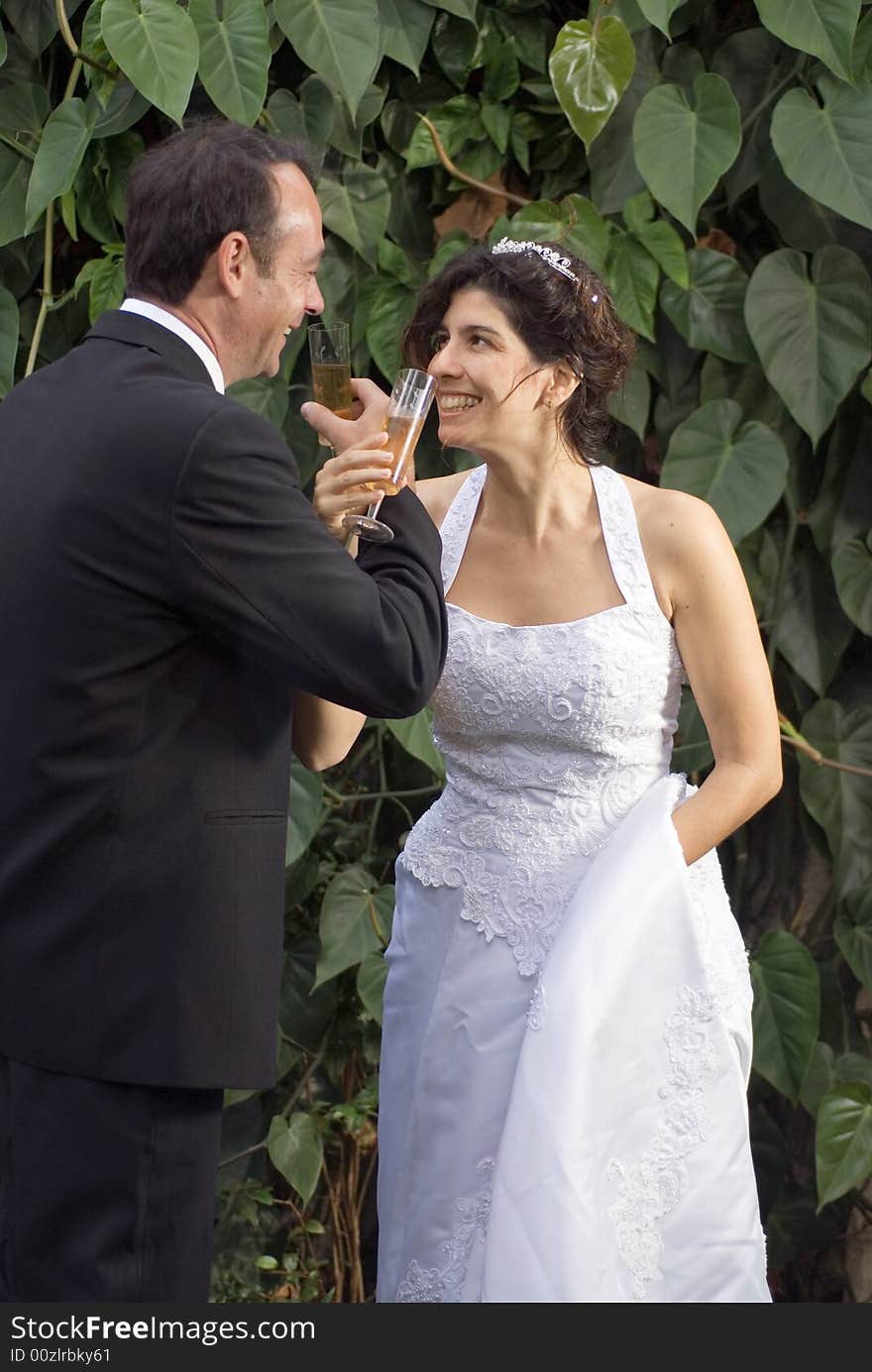 A newly married couple, drink while crossing arms. - vertically framed. A newly married couple, drink while crossing arms. - vertically framed